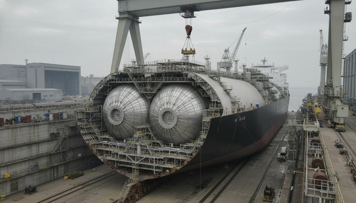 GTT спроектирует танки для семи новых газовозов верфи Hanwha Ocean Большой газовоз СПГ на этапе строительства в сухом доке судостроительной верфи, вид на корпус судна и его внутренние конструкции.